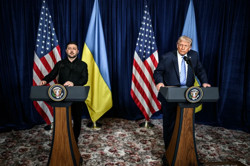 Зеленський і Трамп стоять за трибунами на фоні прапорів США та України
